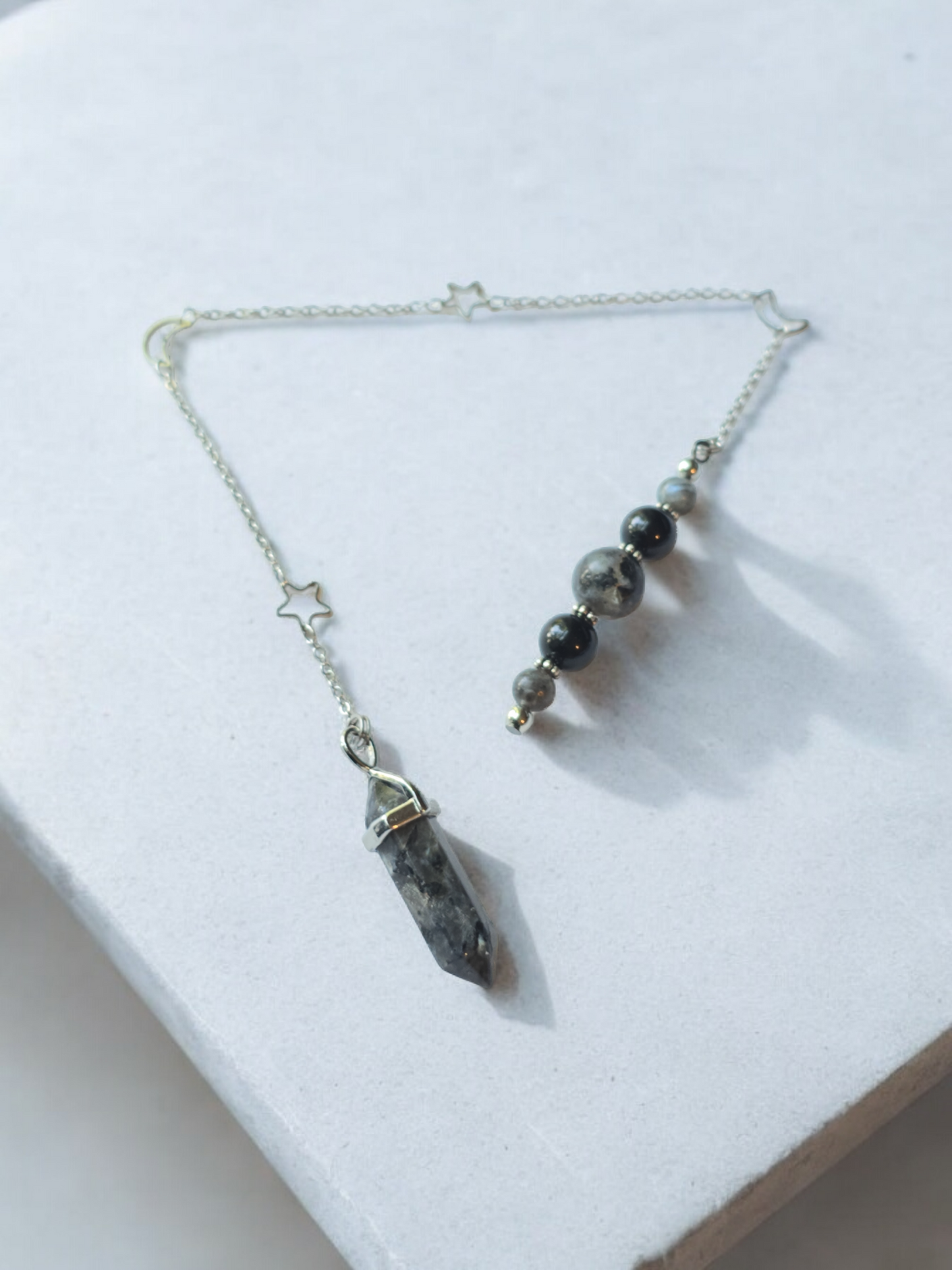 Larvikite crystal pendulum with moon and star chain.